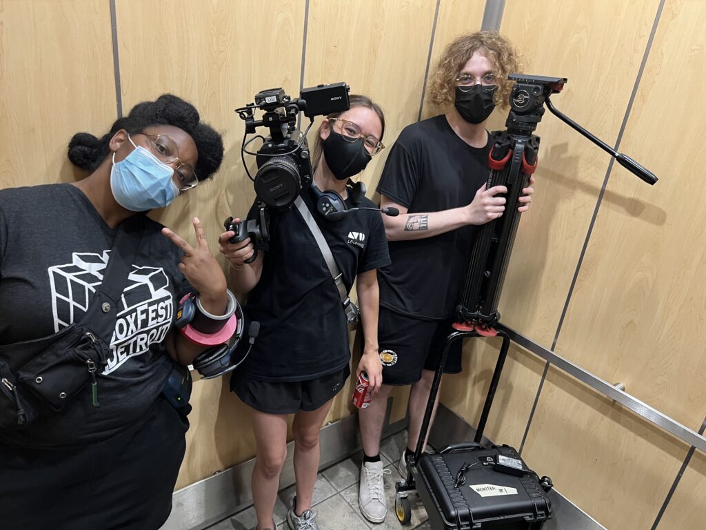 3 people in an elevator with camera equipment